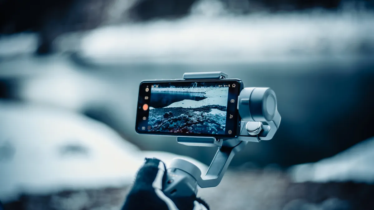 Gimbal vs Tripod: Which One Should You Use for Video? Smartphone mounted on a handheld gimbal