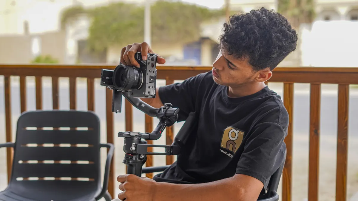 How to calibrate a gimbal for smoother footage person adjusting a camera on a gimbal